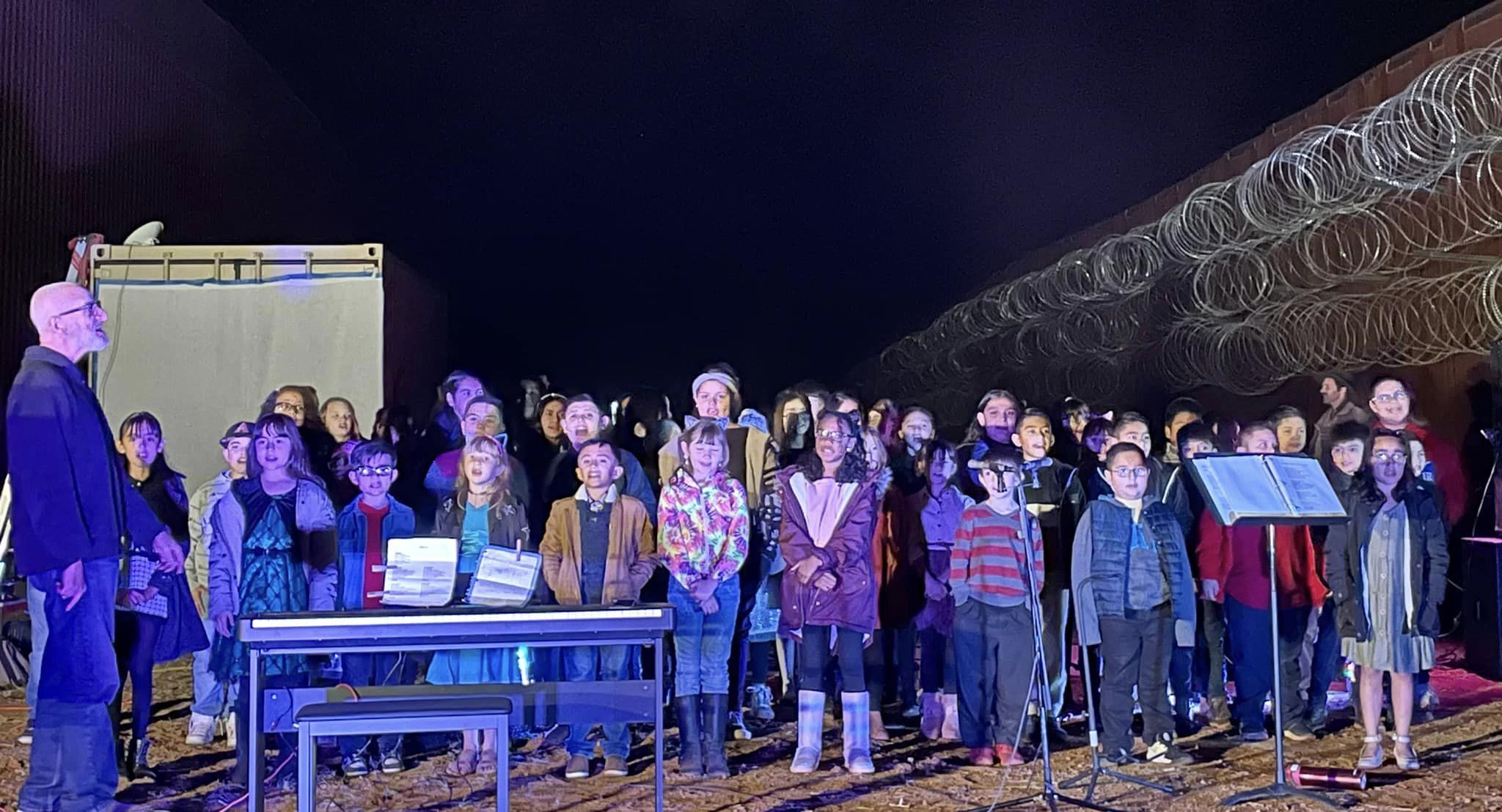 Children sing a concert at the US-Mexico border wall