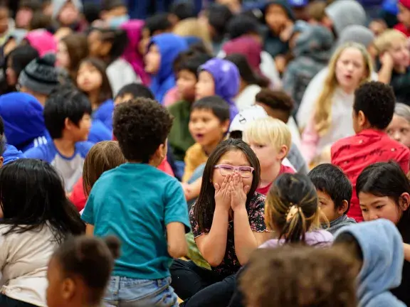 girl laughing in crowd of other children