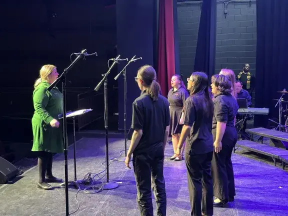 el faro youth chorus on stage directed by director