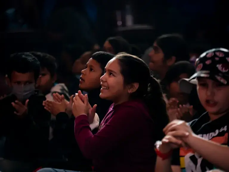 Child watching a musical performance and clapping