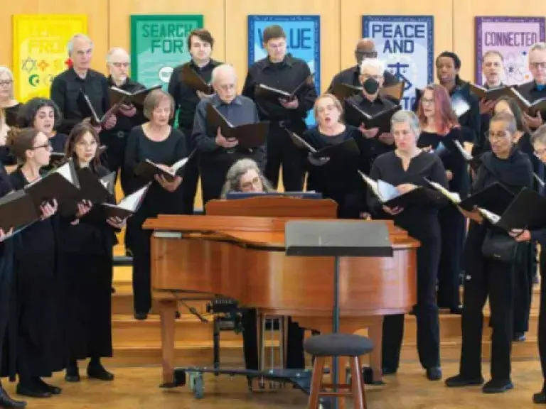 choir singing around piano