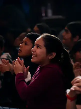 Child watching a musical performance and clapping