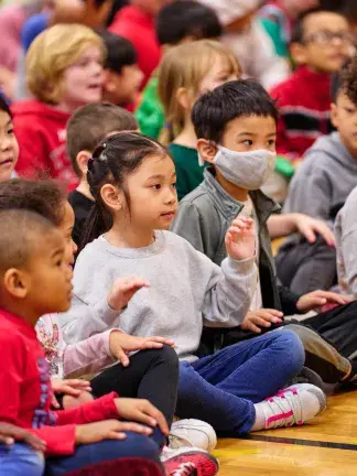 Young children watch singers attentively