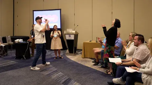 person smiling and clapping in breakout session